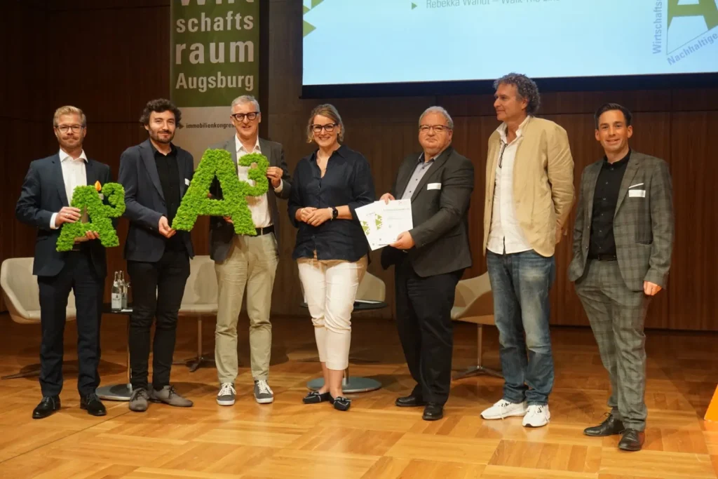 Preisträgerinnen und Preisträger stehen gemeinsam auf der Bühne bei der Verleihung des A³ Immobilien Awards.