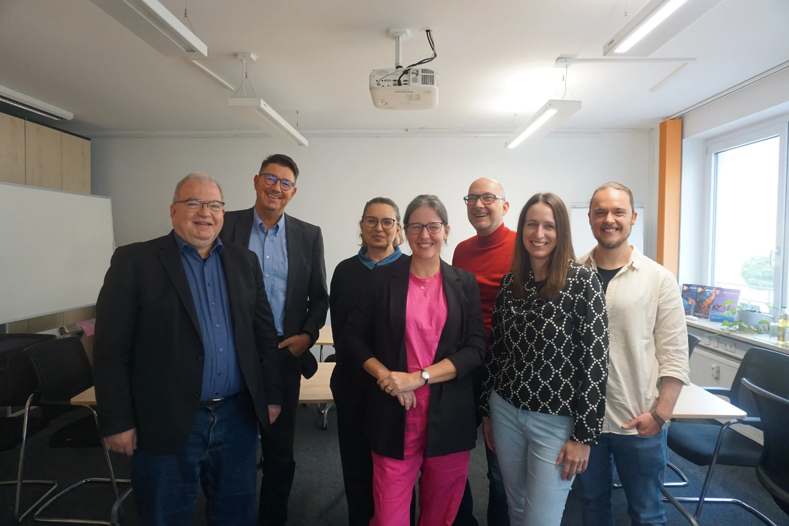 Gruppenfoto aller Teilnehmenden eines Workshops in einem modernen Seminarraum.